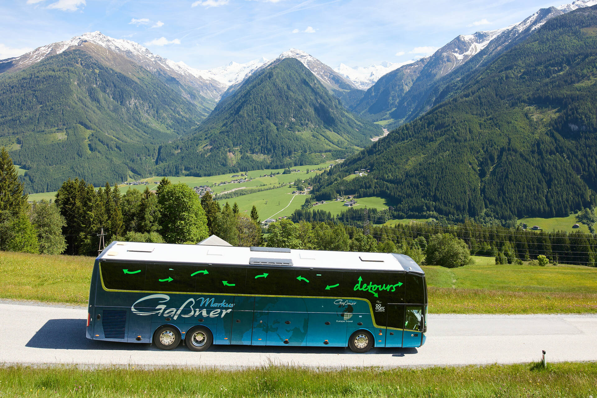 Der Reisebus fährt die Straße runter, die Berge im Hintergrund